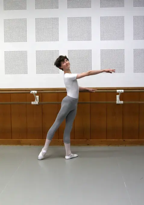 Jeune danseur effectuant une figure de danse classique à la barre