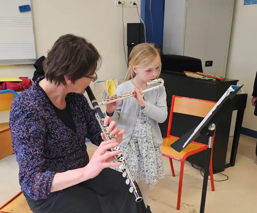 Professeure jouant de la flûte traversière avec une enfant