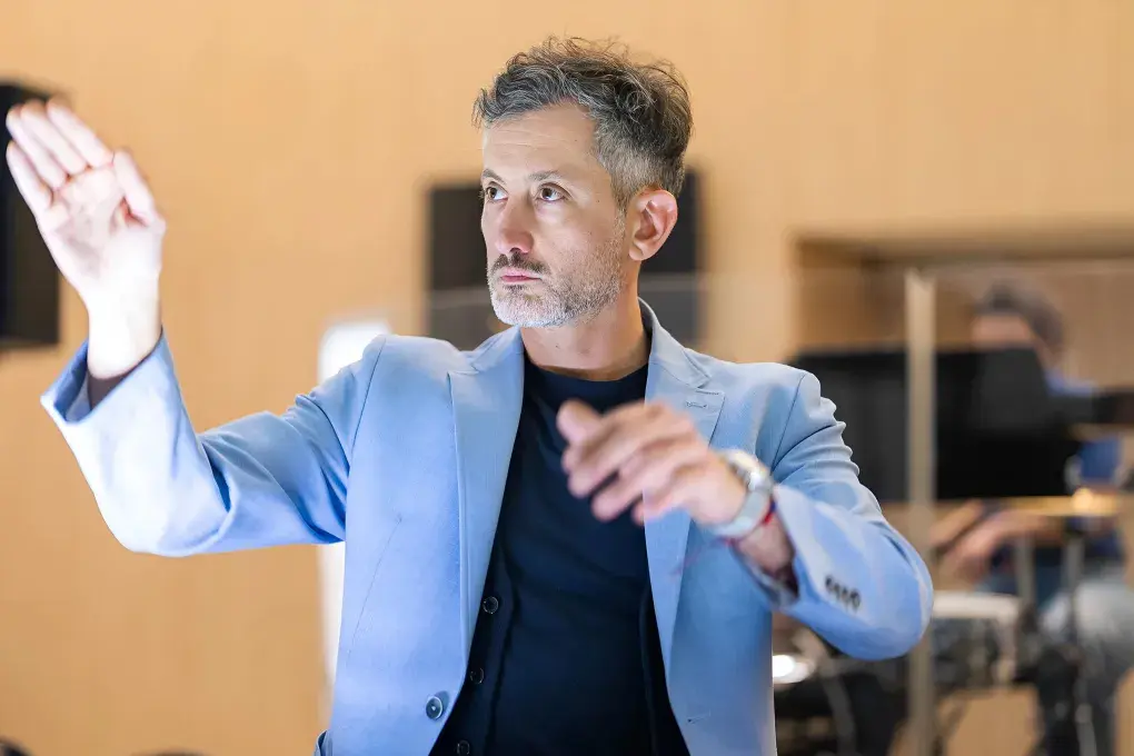 Photo montrant un chef d'orchestre levant les mains