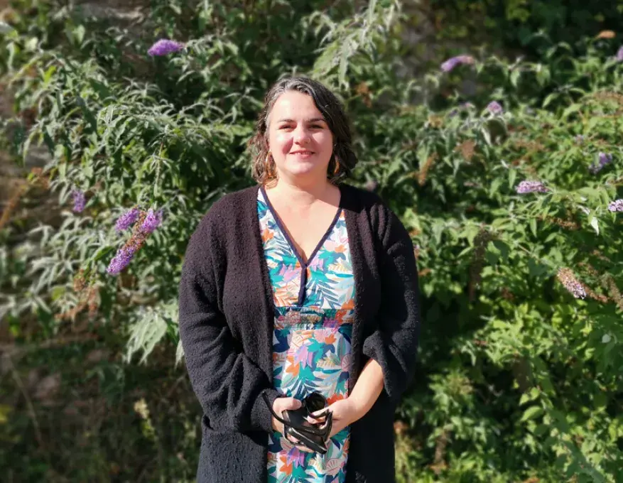 Photo portrait d'Anne-Cécile, posant debout en extérieur dans un jardin