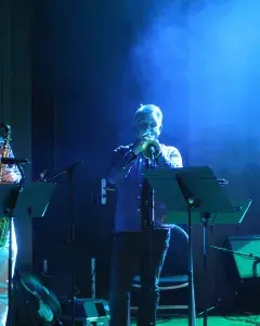 Photo montrant 1 saxophoniste et un trompettiste jouant en concert sur une scène