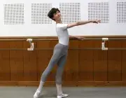 Jeune danseur effectuant une figure de danse classique à la barre