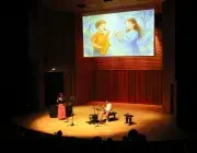 Photo montrant deux instrumentistes (flûte traversière et saxophone) jouant sur une scène