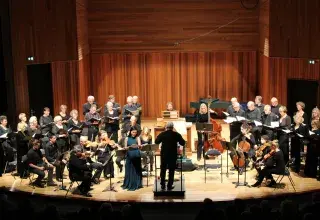 Photo montrant un ensemble baroque et une chanteuse dirigés par un chef d'orchestre