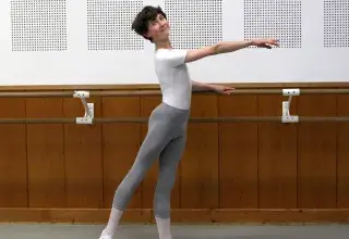 Jeune danseur effectuant une figure de danse classique à la barre