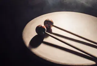 Photo montrant une percussion en peau avec 2 baquette posées dessus