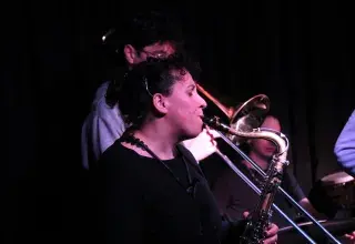 Photo montrant une jeune femme jouant du saxophone et un jeune homme jouant du trombone