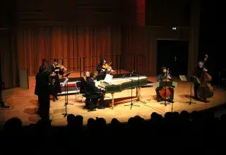Photo montrant des musiciens jouant sur scène : clavecin, flûte, contrebasse, violoncelle, alto et violon.