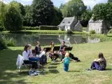 Photo du Brin classik 2022 montrant un groupe de flûtistes dans un jardin jouant de la musique devant des spectacteurs assis dans l'herbe