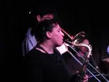 Photo montrant une jeune femme jouant du saxophone et un jeune homme jouant du trombone